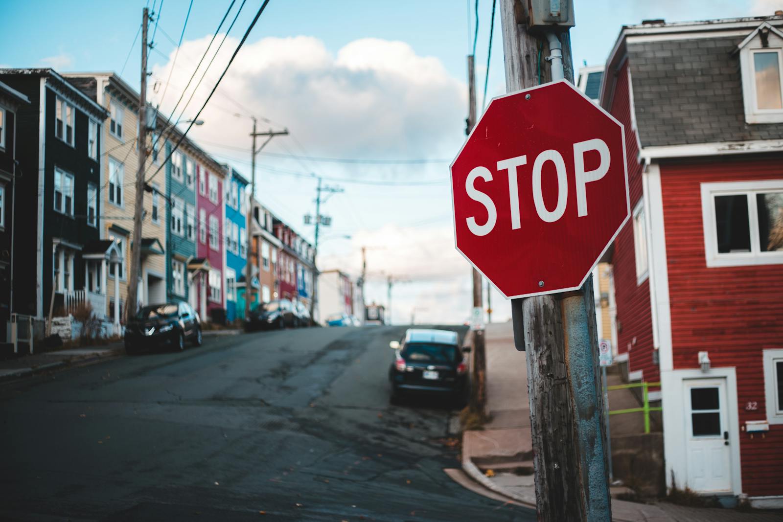 Colorful urban street scene with a prominent stop sign in the foreground.