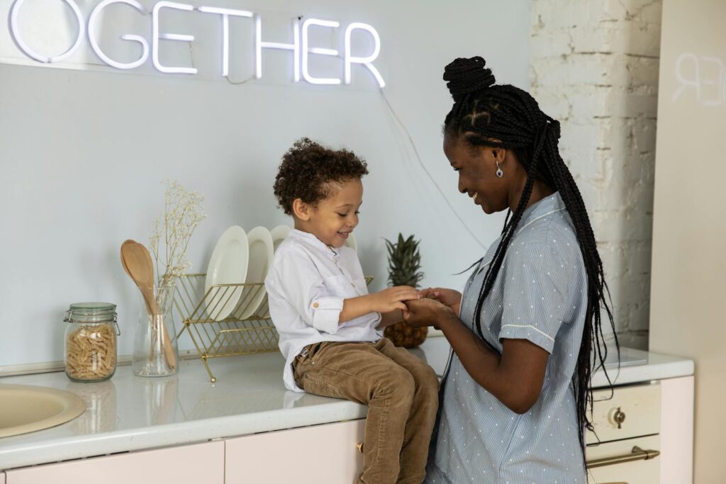 Warm moment between mother and son sitting in a stylish kitchen, sharing happiness.