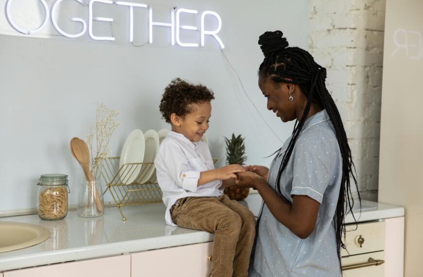 Warm moment between mother and son sitting in a stylish kitchen, sharing happiness.