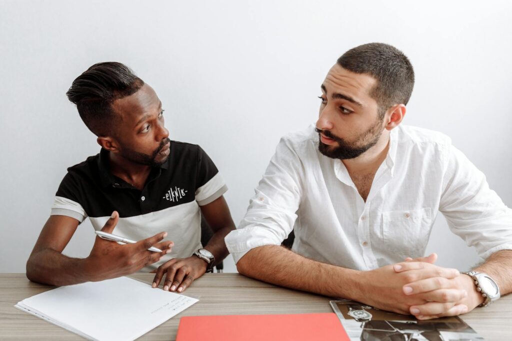 Two diverse men engage in a serious office discussion, emphasizing collaboration and teamwork.