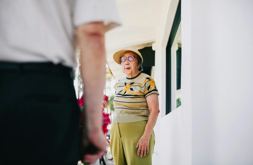 A senior woman is surprised as she receives flowers from a man on a sunny day. Capturing affection and unexpected joy.