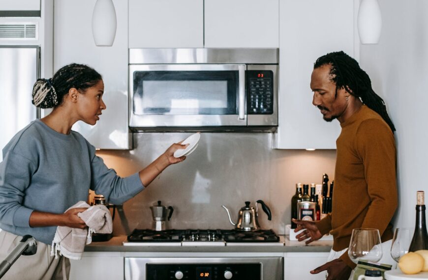 Side view of young black woman talking to dissatisfied male partner during conflict in house