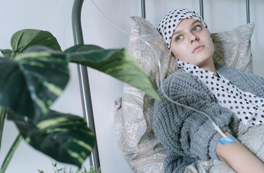 Young woman in hospital bed receiving cancer treatment, reflecting resilience.