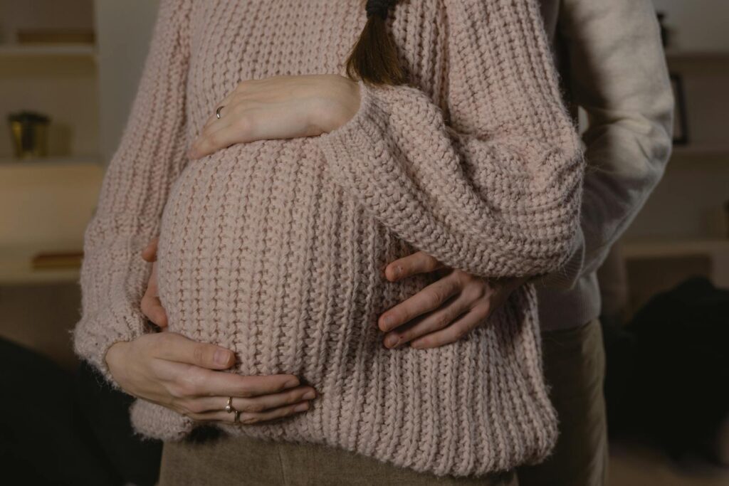 Close-up of a loving couple embracing during pregnancy, highlighting warmth and intimacy.