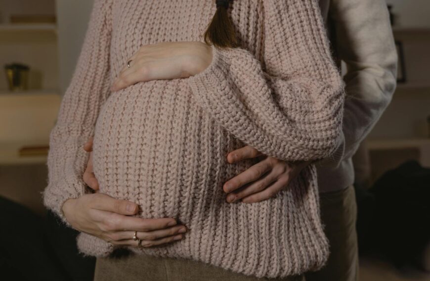 Close-up of a loving couple embracing during pregnancy, highlighting warmth and intimacy.