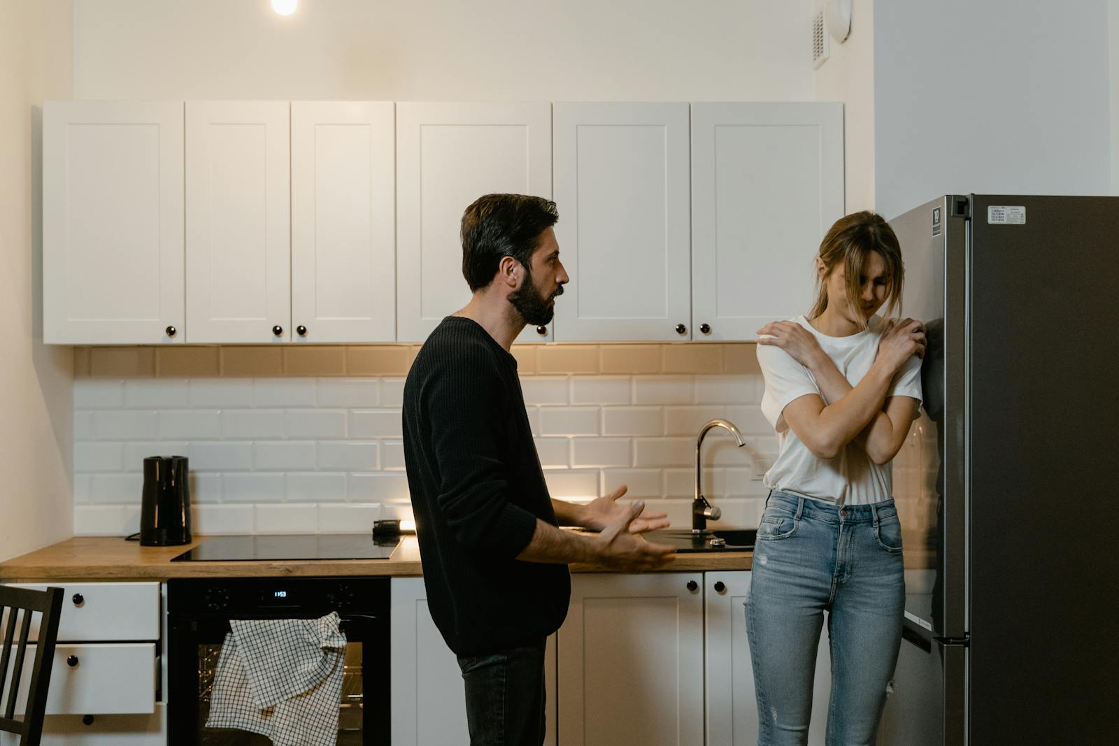 A couple argues in a modern kitchen, illustrating emotional tension and relationship challenges.