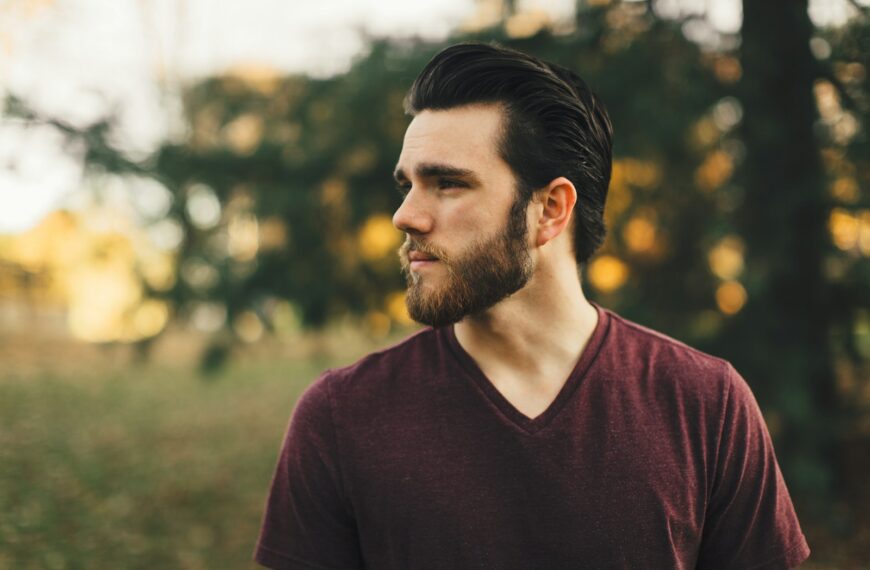 man wearing maroon V-neck t-shirt in forest