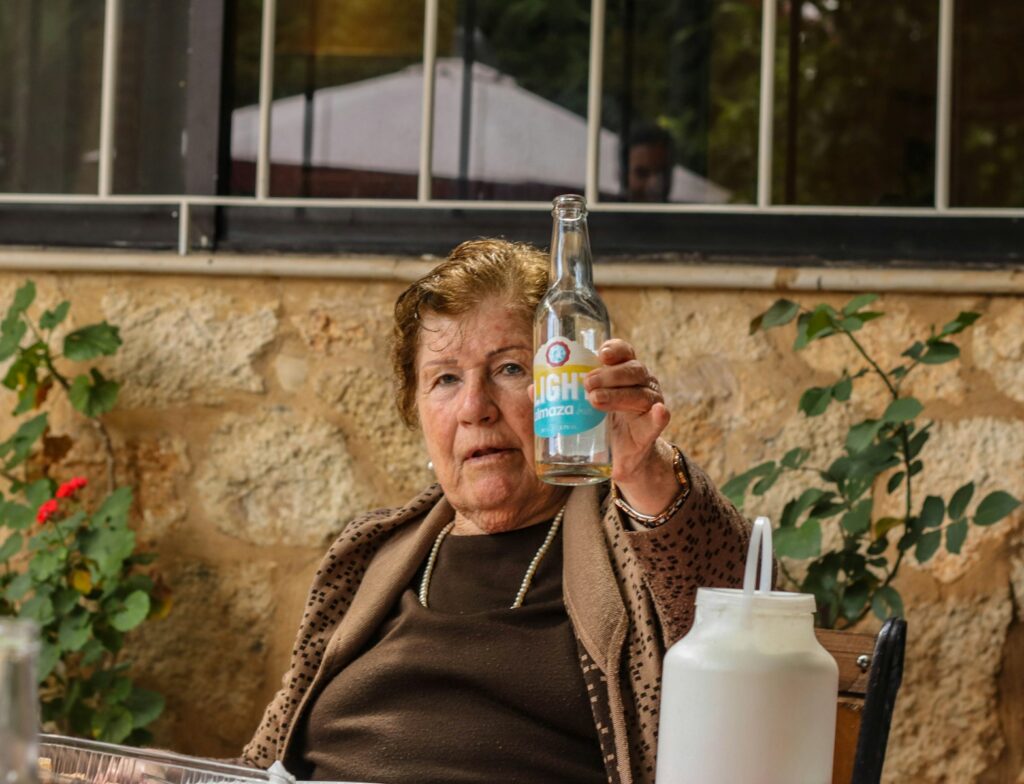 a woman sitting at a table with a bottle of water