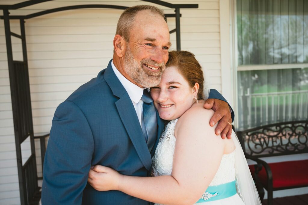 a man and woman hugging each other in front of a house