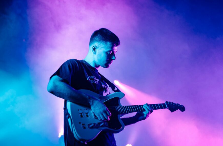 man in black crew neck t-shirt playing electric guitar