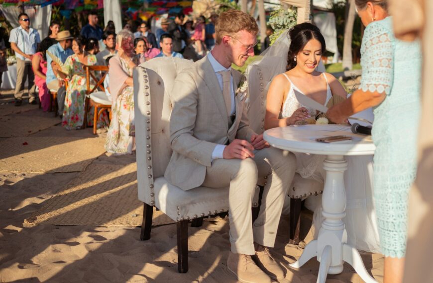 Bride and groom signing wedding certificate on beach