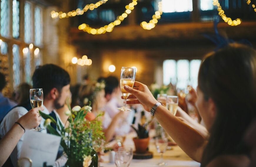 people raising wine glass in selective focus photography