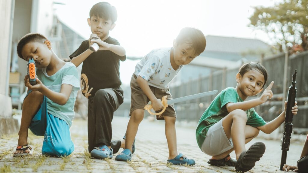 Boys are playing with various toy weapons.