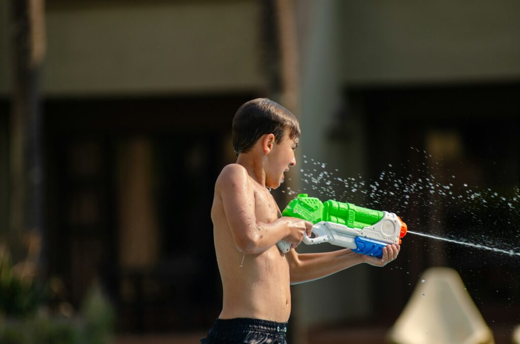 a young boy playing with a water gun