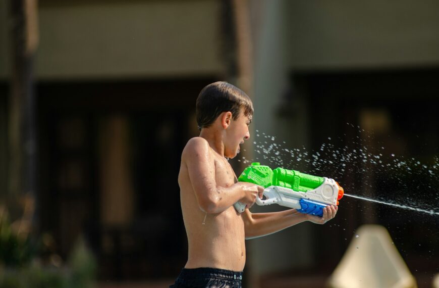 a young boy playing with a water gun