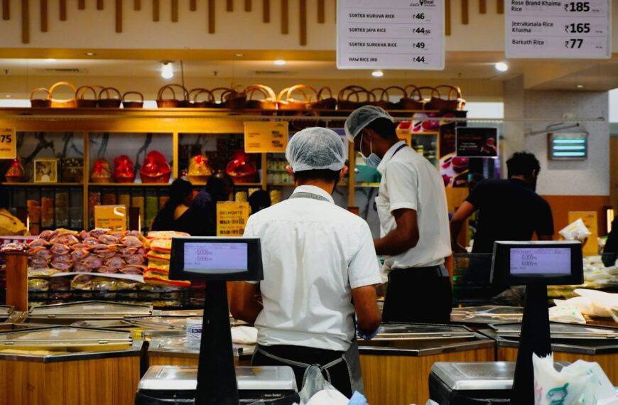 Workers in a grocery store checkout area