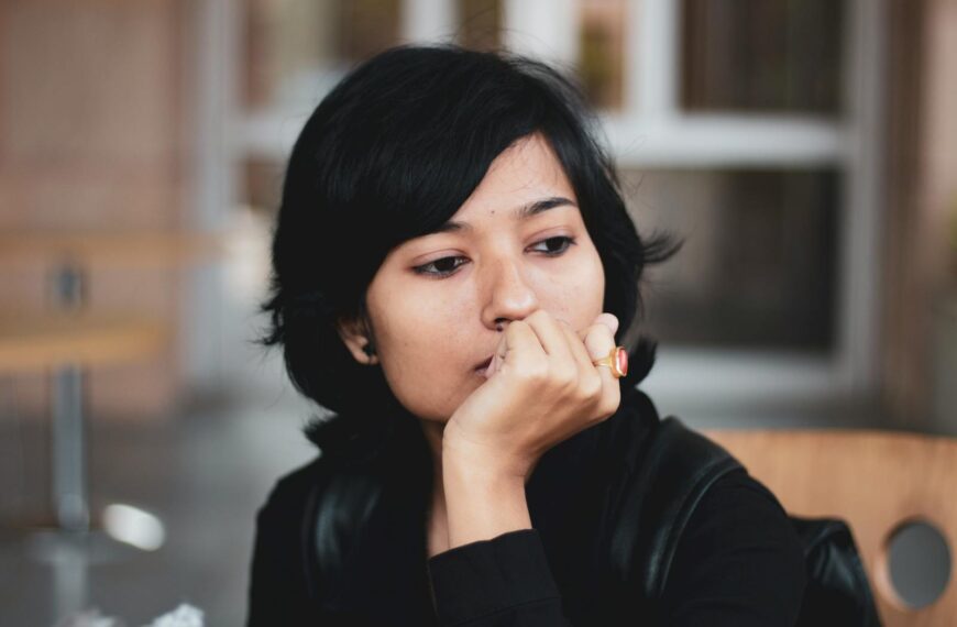 Portrait of a thoughtful woman indoors, lost in contemplation.
