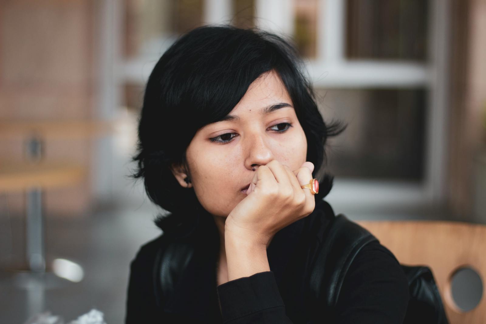 Portrait of a thoughtful woman indoors, lost in contemplation.