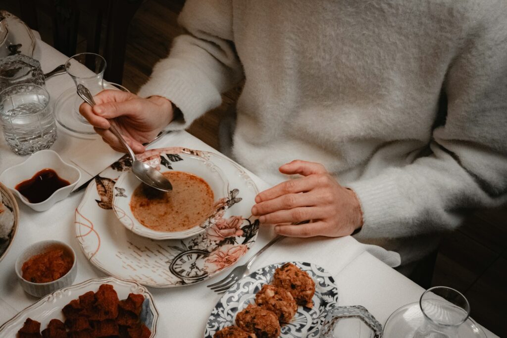 Person eating a bowl of soup with a spoon.