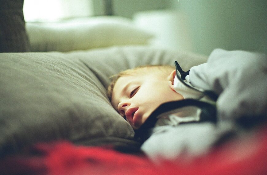 boy in white and black hoodie lying on bed