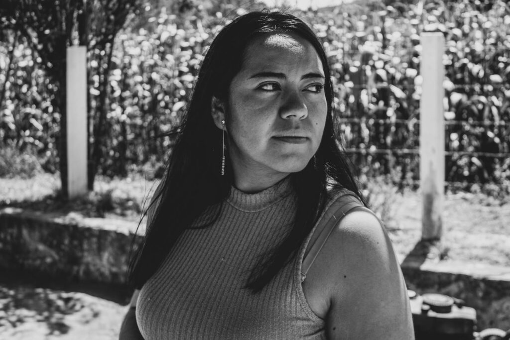 Emotive black and white portrait of a woman outdoors in a Mexican farm field.