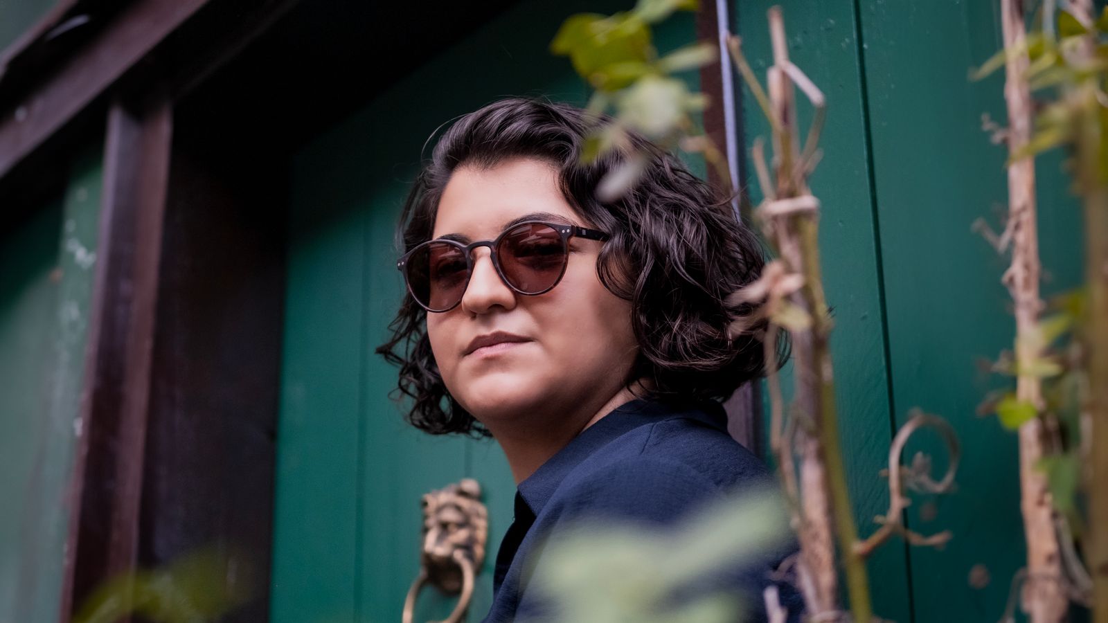 Stylish woman in sunglasses posing confidently outdoors in Ankara.