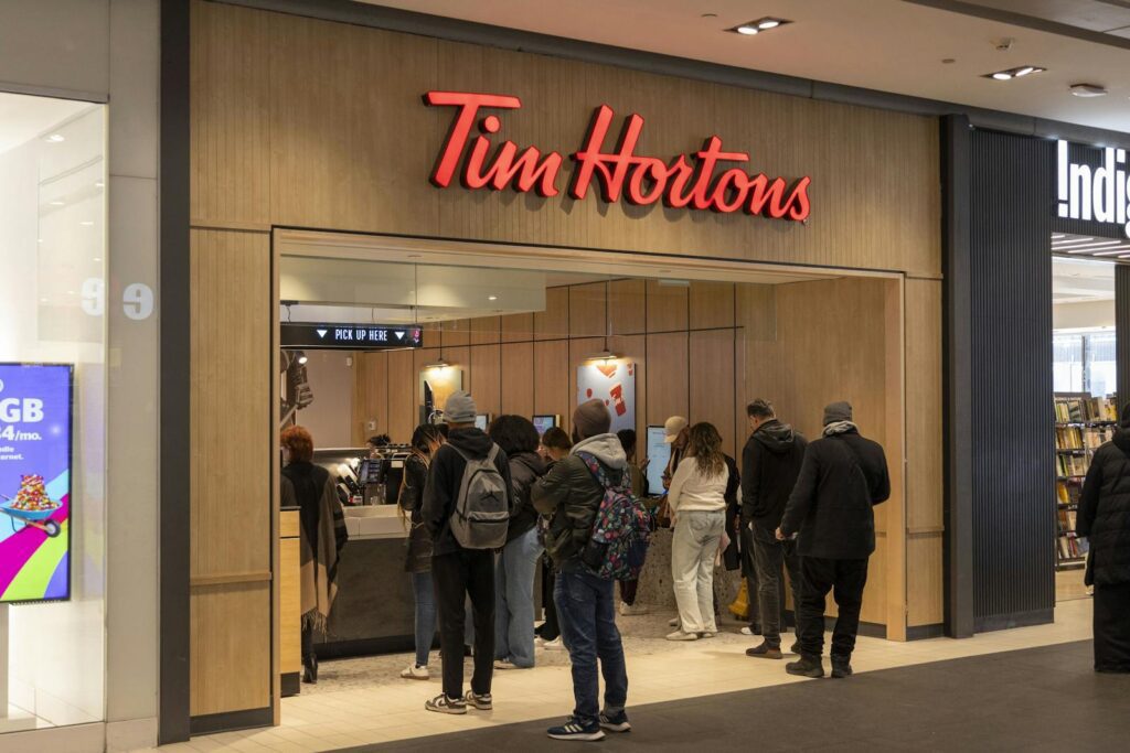 Busy Tim Hortons with customers waiting in line at the counter.