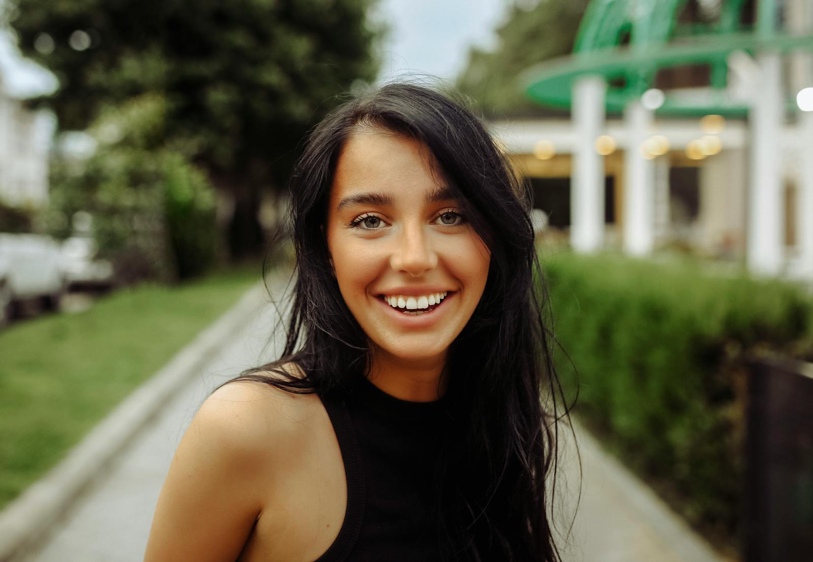 Captivating portrait of a cheerful young woman outdoors in Tbilisi, showcasing natural beauty.