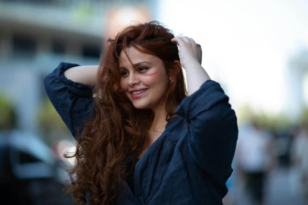 Portrait of a smiling woman with flowing hair on a sunny day in Baku, Azerbaijan.