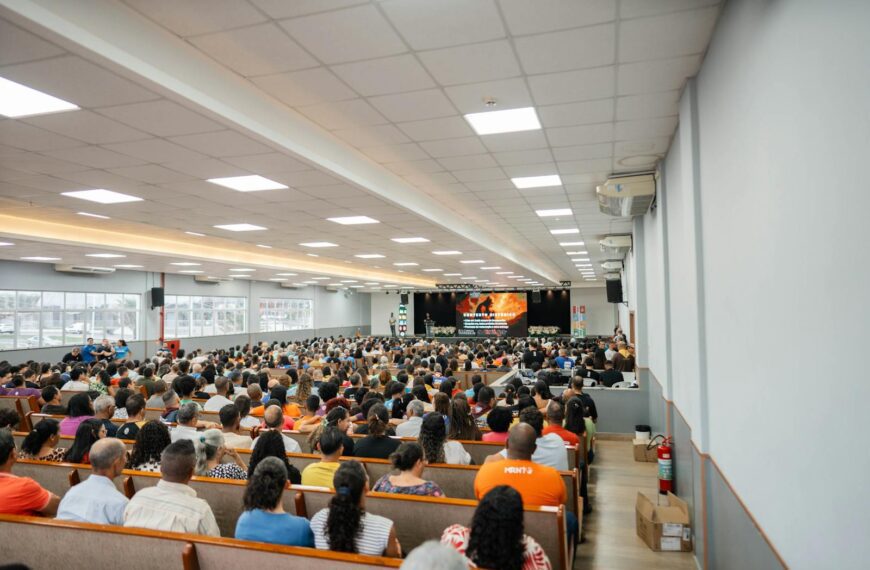 Large audience gathered in a spacious auditorium for a presentation or event with stage view.