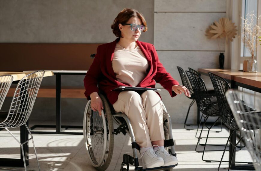 Stylish woman in wheelchair inside a brightly lit café, showcasing accessibility and lifestyle.