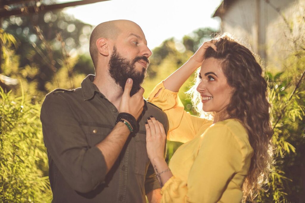 Happy couple enjoying a sunny day outdoors, embracing and smiling at each other.