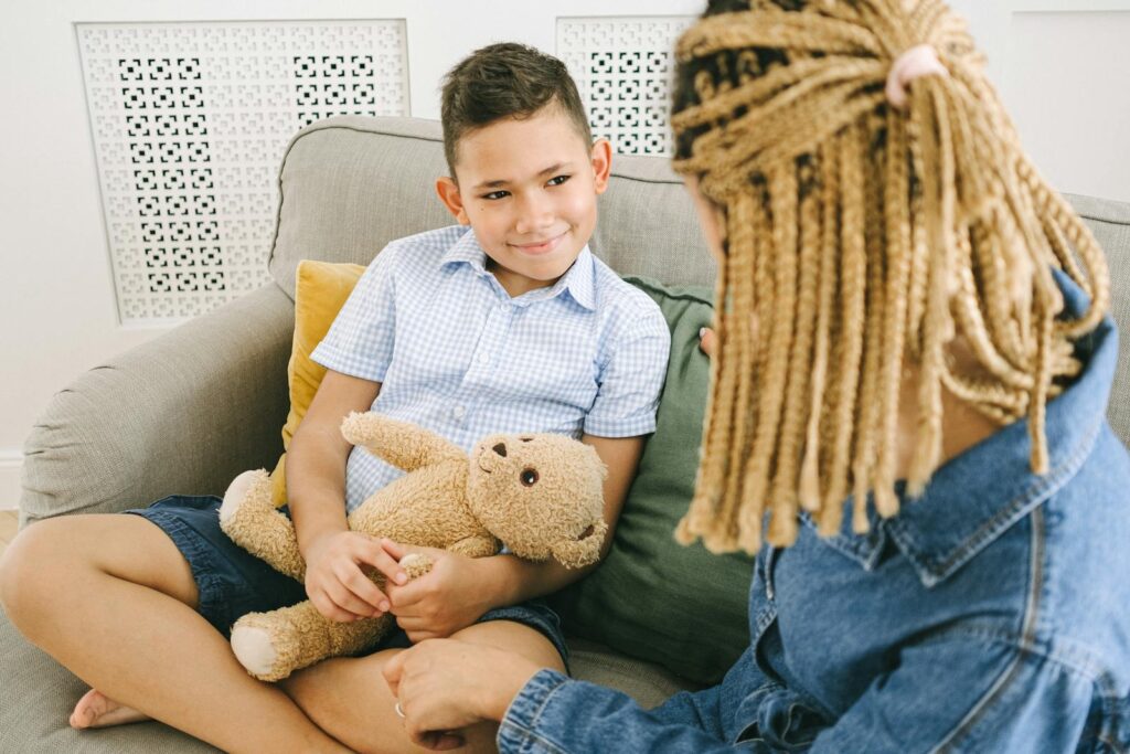 A warm family interaction capturing a mother and son sitting together indoors with smiles.