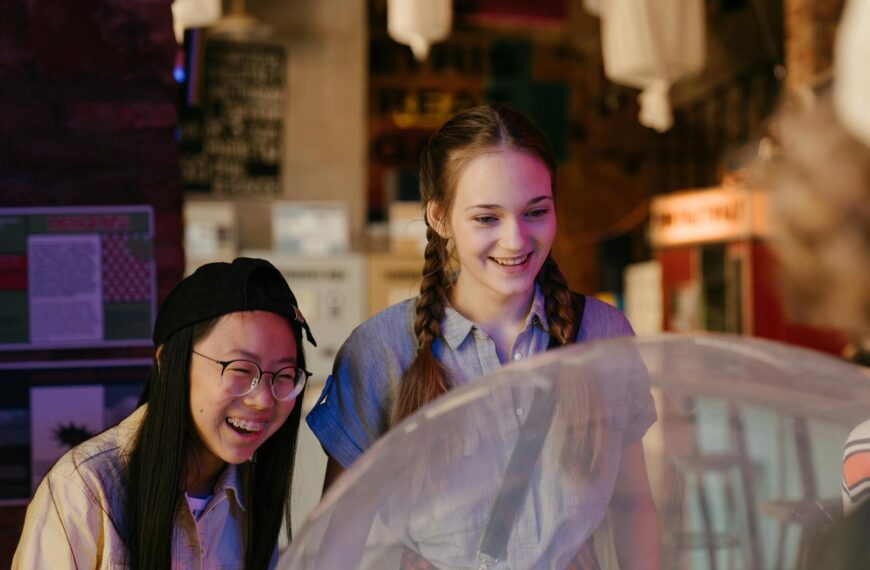 Diverse group of teenagers having a joyful time at an arcade, playing games together.