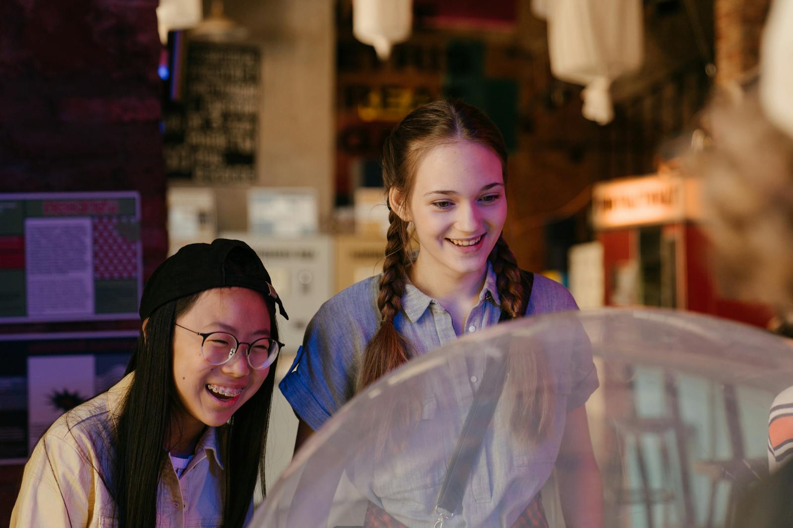 Diverse group of teenagers having a joyful time at an arcade, playing games together.