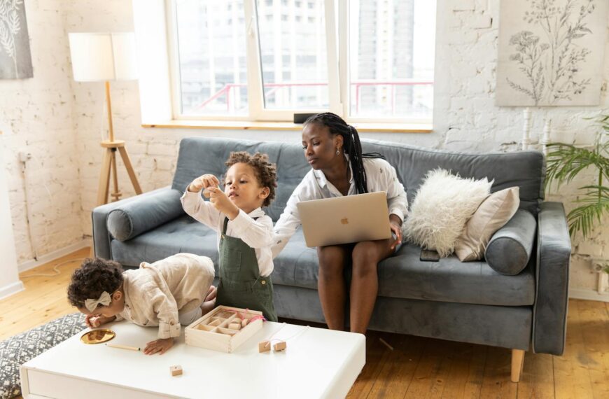 Mother and children spending quality time at home, playing and using a laptop.