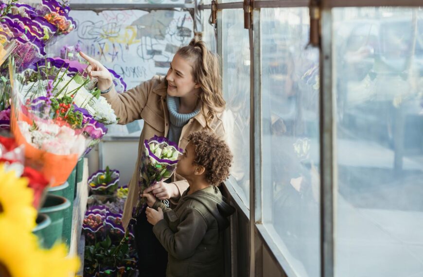 A woman and a child selecting vibrant flowers in a flower shop, enjoying a bonding moment.