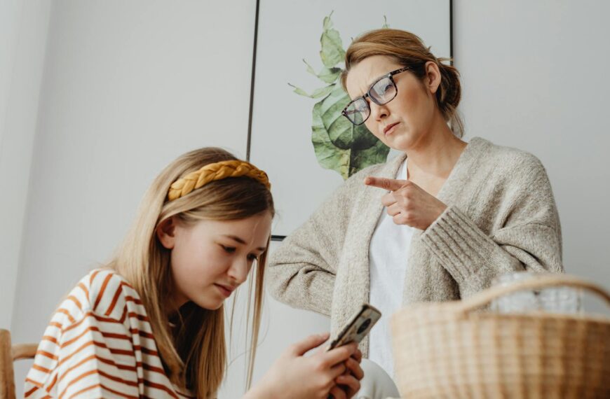 A mother scolds her teenage daughter for excessive phone use at home.