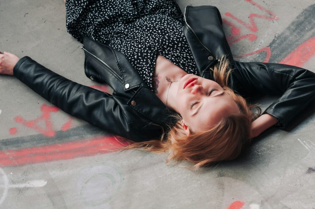 a woman laying on the ground with her eyes closed
