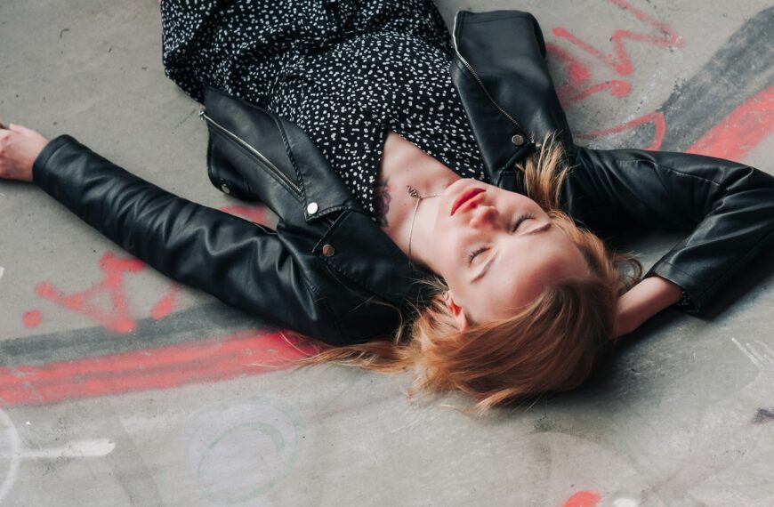 a woman laying on the ground with her eyes closed