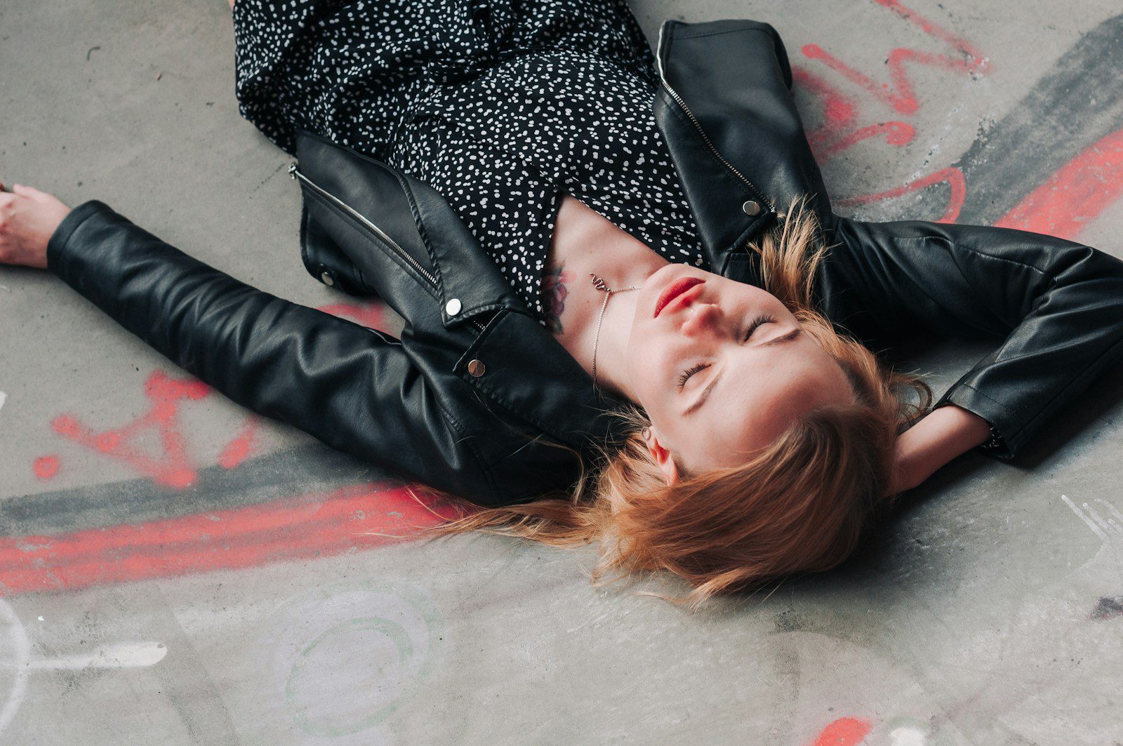 a woman laying on the ground with her eyes closed