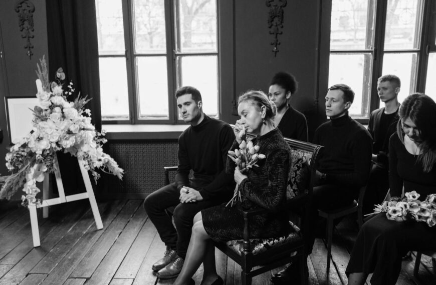 Grieving family members gather at a funeral, displaying emotions and support.
