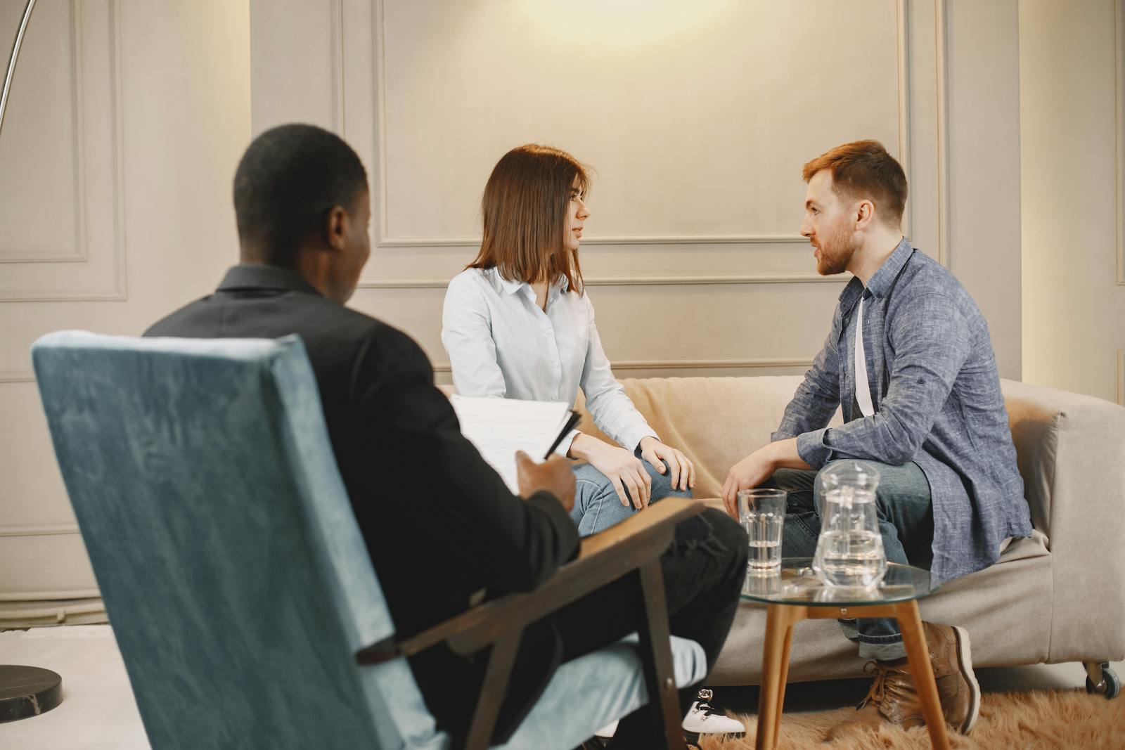 Couple in a counseling session with a therapist in a modern and cozy setting.