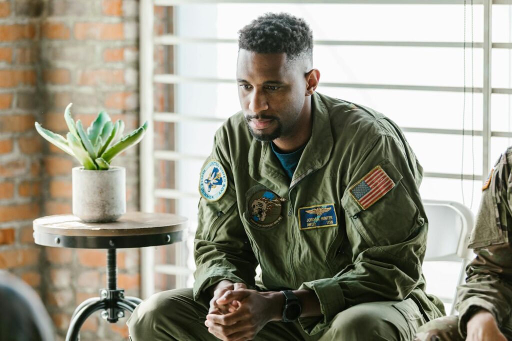 Thoughtful military veteran in uniform listening intently indoors.