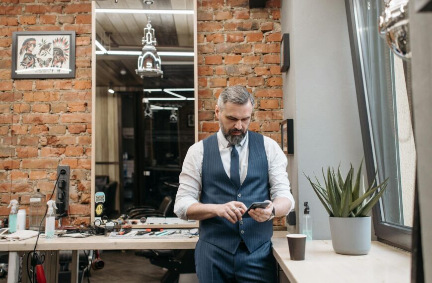 Businessman in a stylish barber shop checking phone. Modern and classic decor.