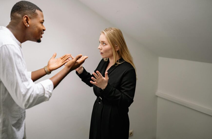 A man and woman having a heated discussion in a minimalistic indoor space.
