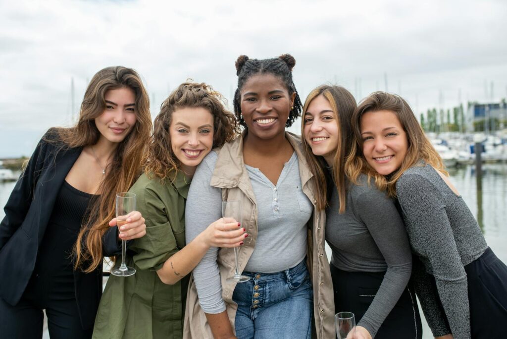 A diverse group of cheerful women smiling and enjoying their time by the marina in Portugal.