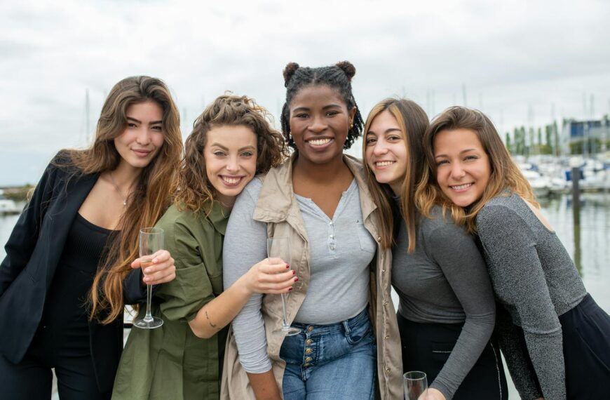 A diverse group of cheerful women smiling and enjoying their time by the marina in Portugal.