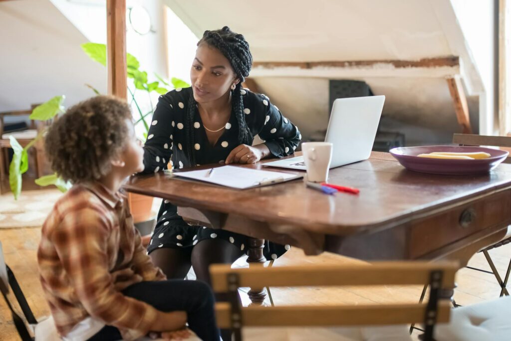 A mother and son spending quality time together at a table, engaged in conversation and homework.