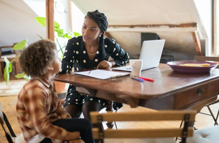 A mother and son spending quality time together at a table, engaged in conversation and homework.